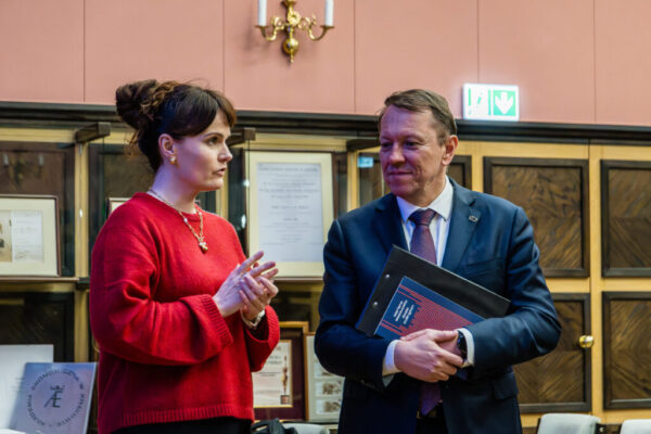 kobieta w czerwieni i mężczyzna w garniturze w sali UEK